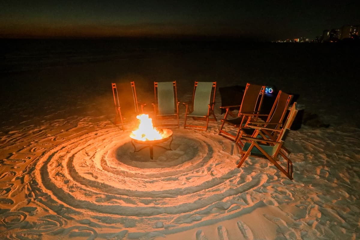 Rehearsal dinner gathering around beach bonfire