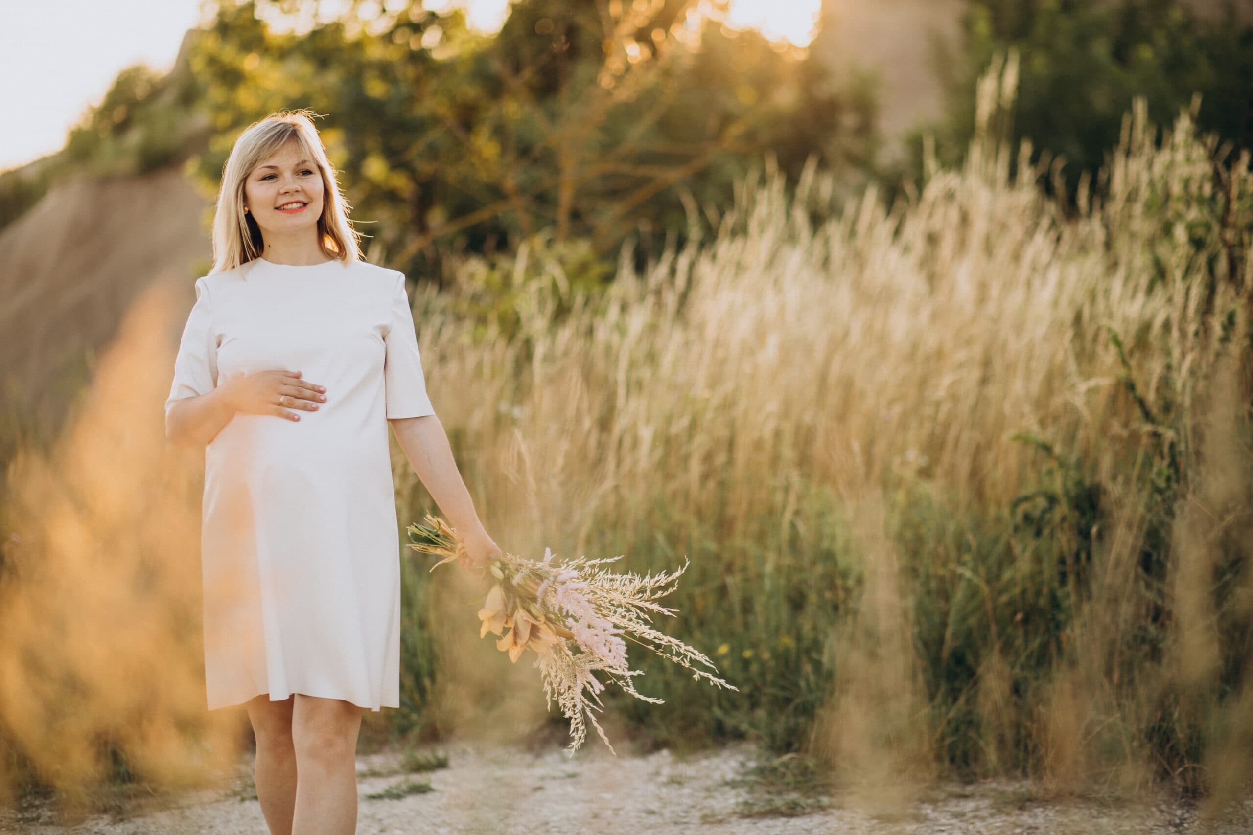 A pregnant woman posing for beach maternity photoshoot