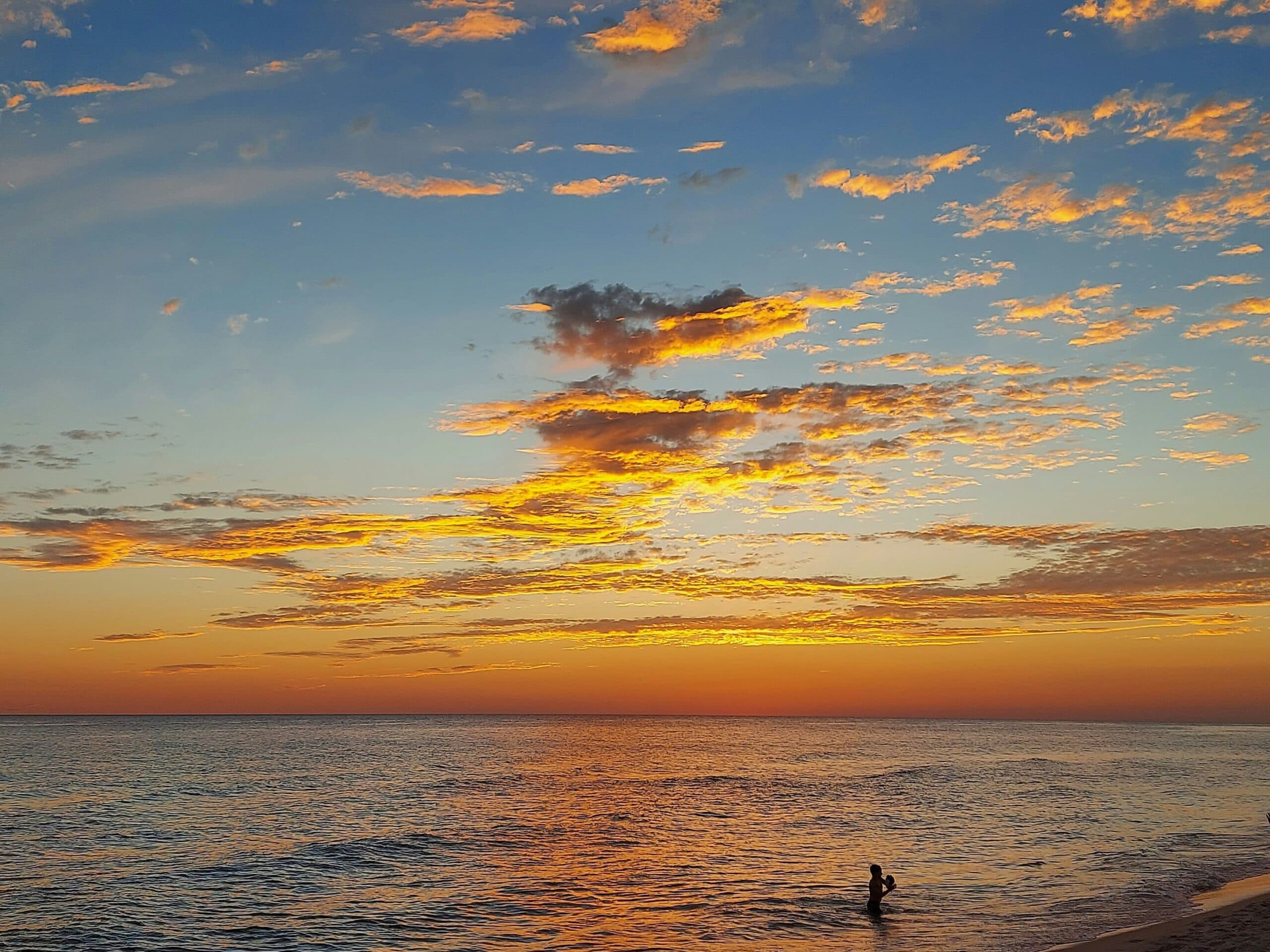 Person silhouetted against a golden sunset.