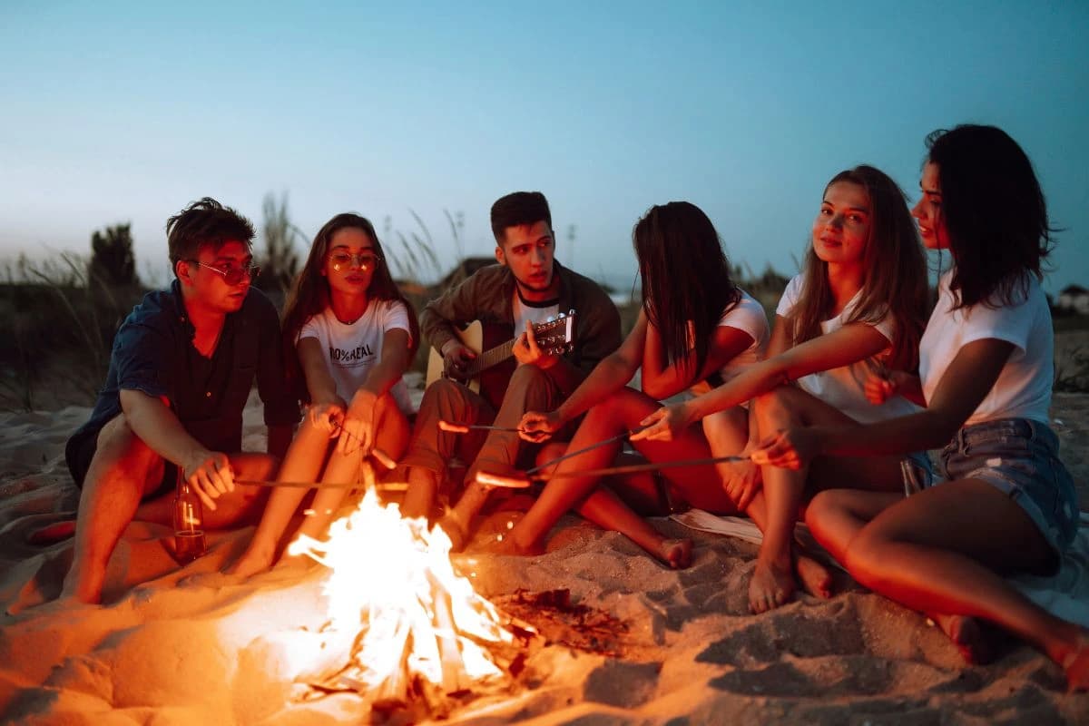 Friends hanging out at beach bonfire